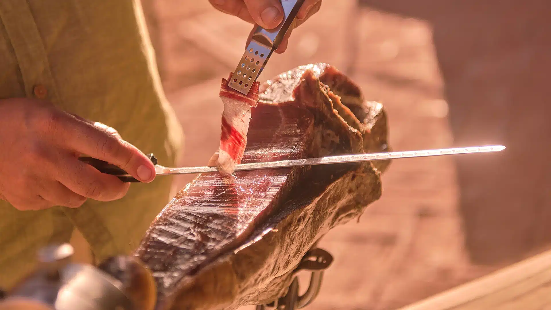Plano detalle del corte fino de jamón ibérico con grasa brillante y veteado natural