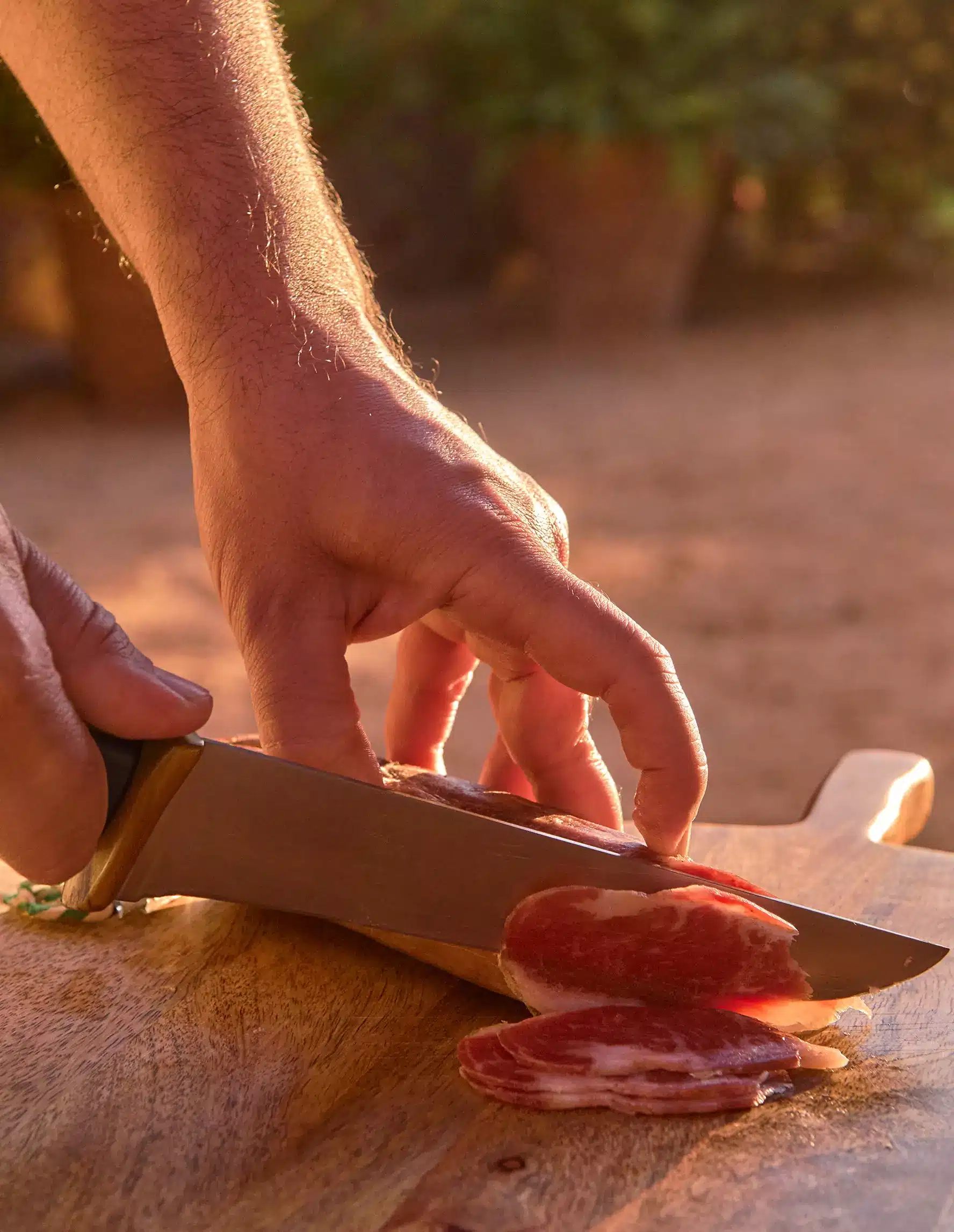 Plano detalle de mano cortando loncha de lomo ibérico de Dehesa Monteros