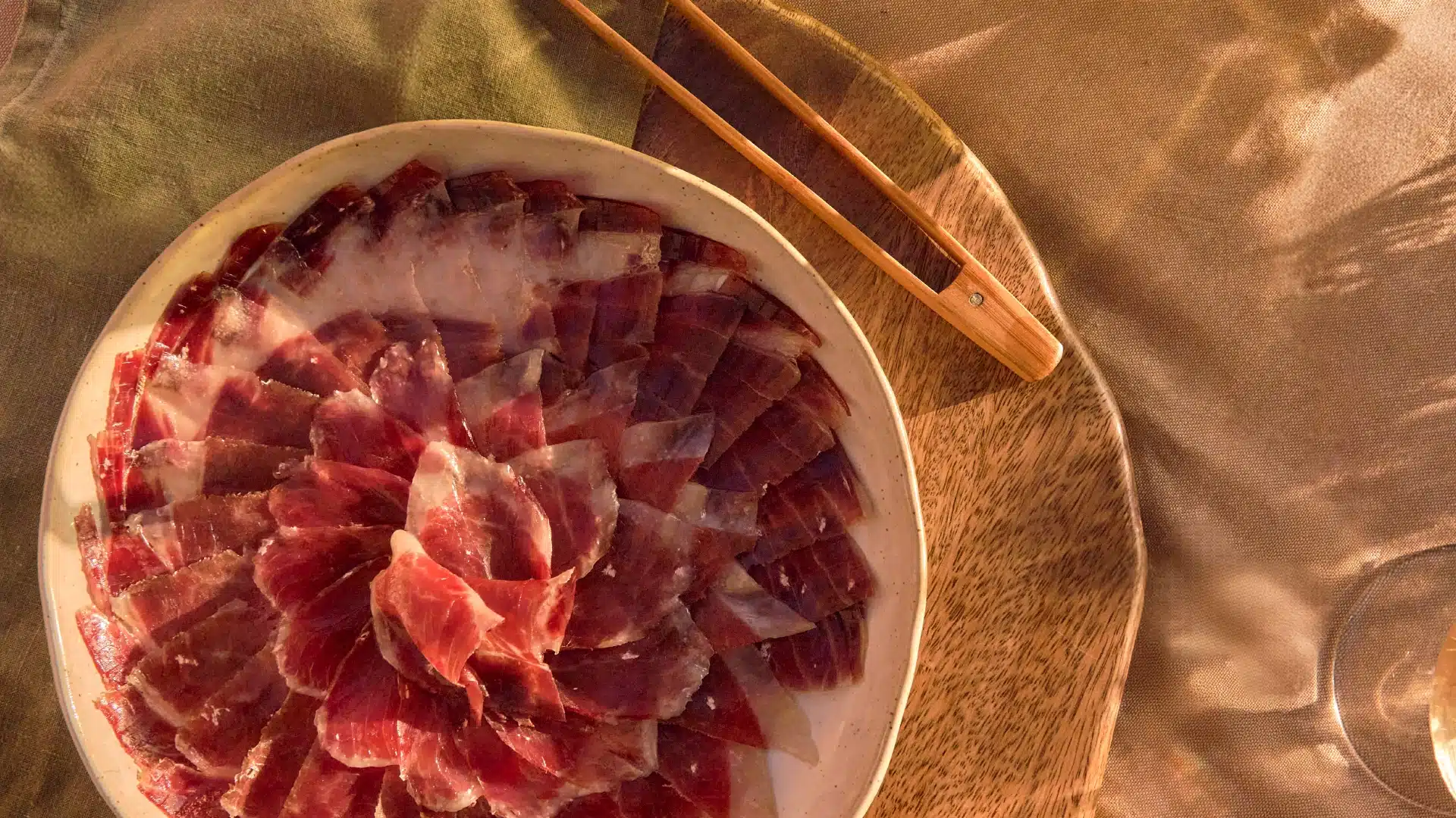 Fotografía cenital de plato de jamón ibérico con corte preciso