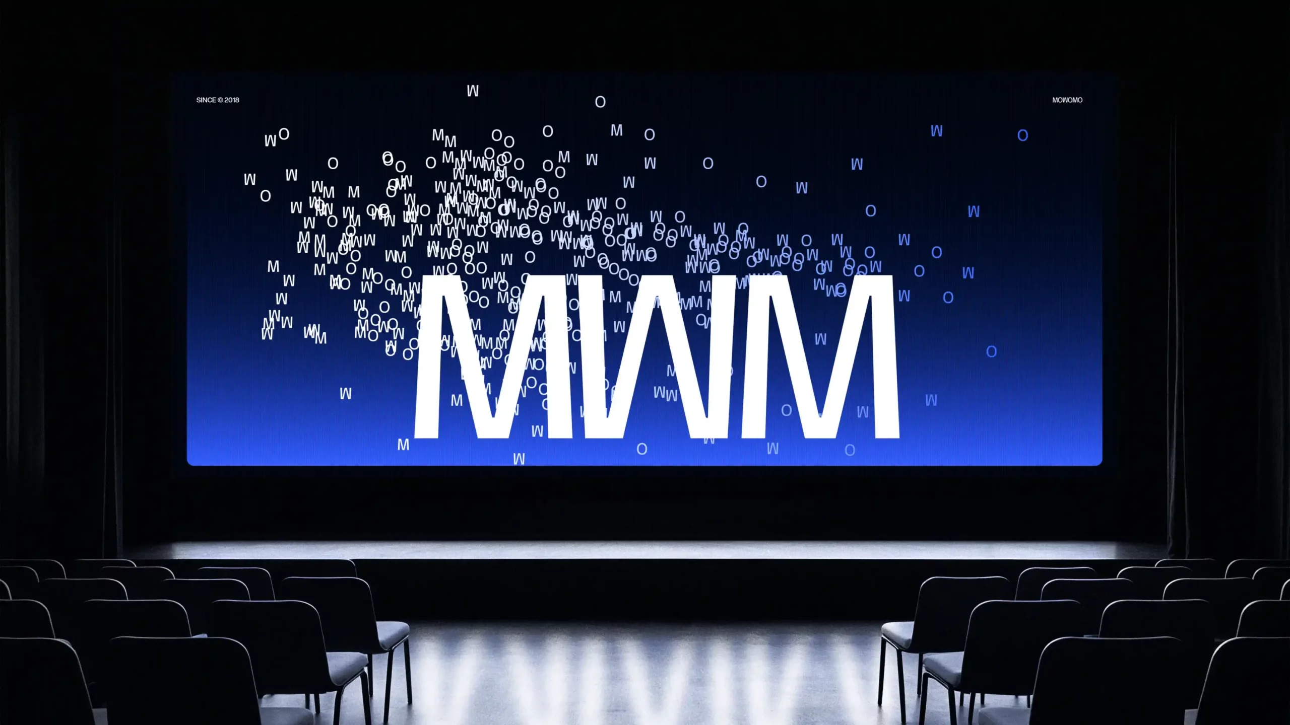 Presentación de la identidad corporativa de Mowomo en una pantalla de gran formato durante un evento.
