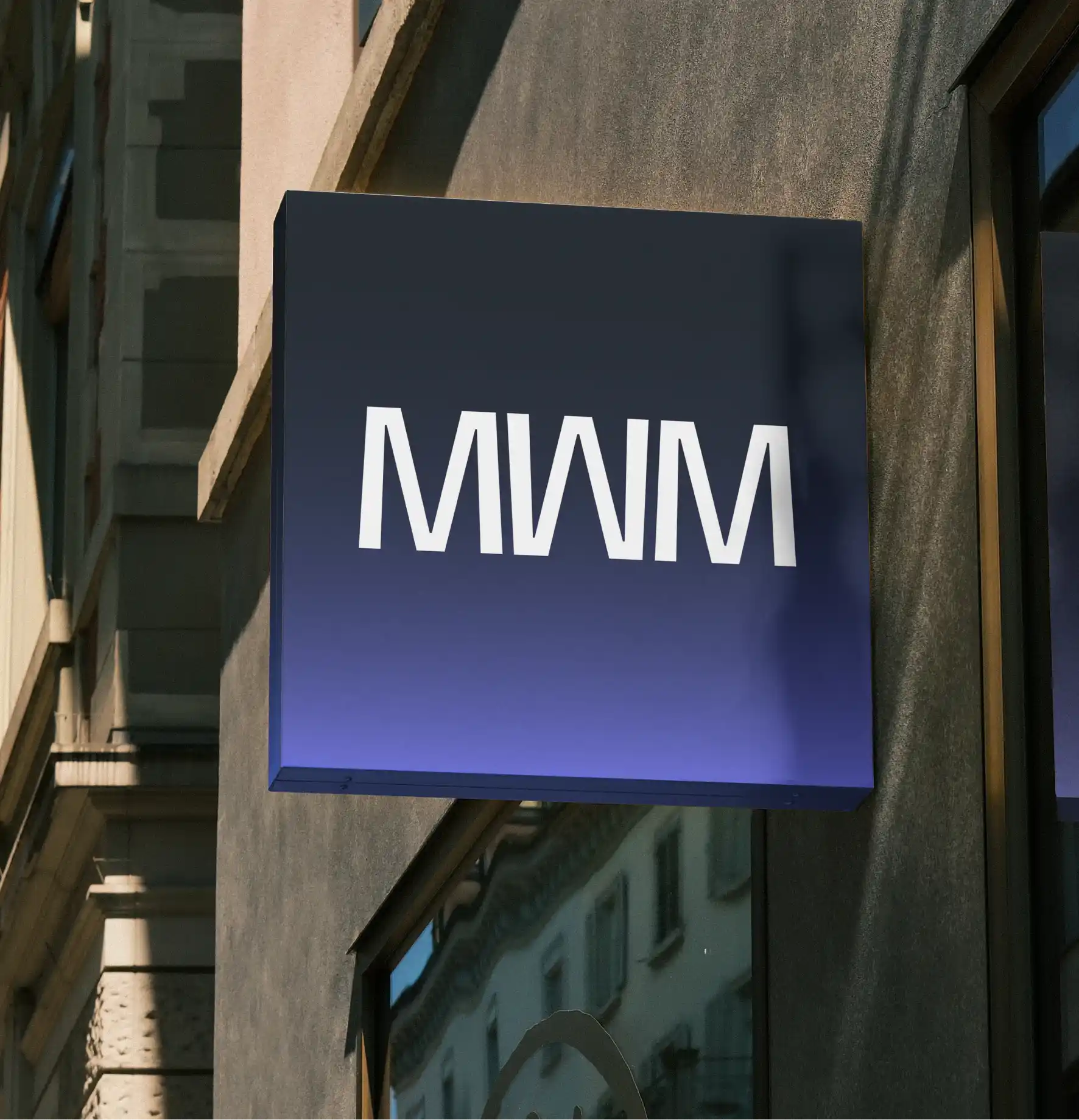 Rótulo exterior con la identidad visual de Mowomo aplicado a la fachada de un edificio.