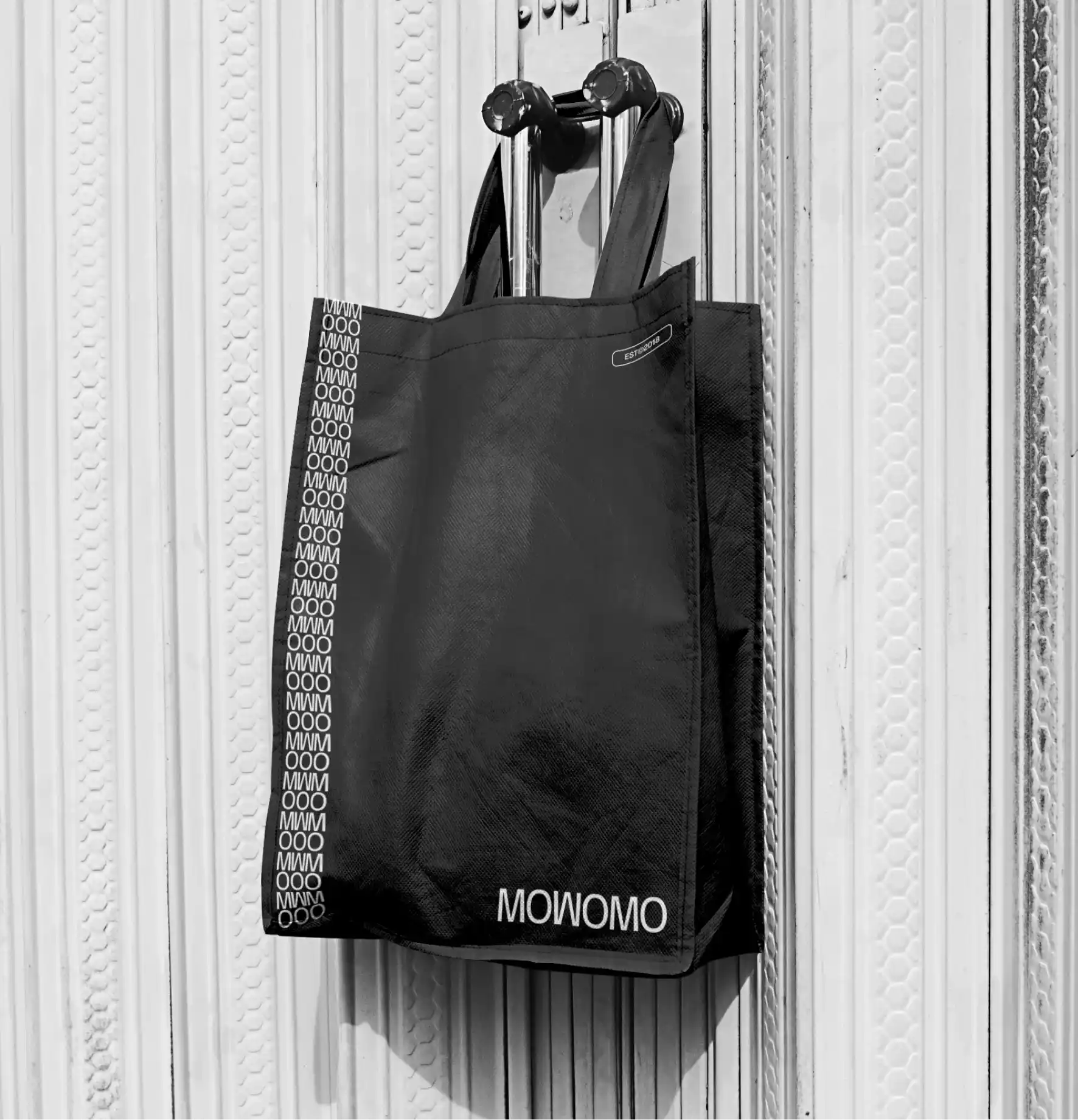 Tote bag corporativa negra personalizada con el logotipo e identidad visual de Mowomo.